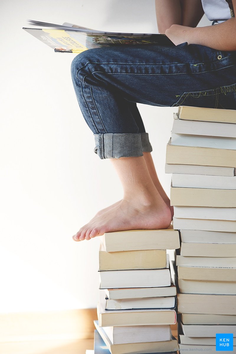 Student sitting on books